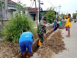 Babinsa Balongpanggang Bersama Warga Laksanakan Karya Bakti Perbaikan Jalan Paving Desa